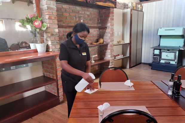 Staff member disinfecting table